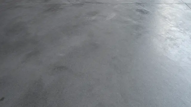 Top view of a smooth dark gray polished concrete floor filling the full frame with subtle reflective sheen