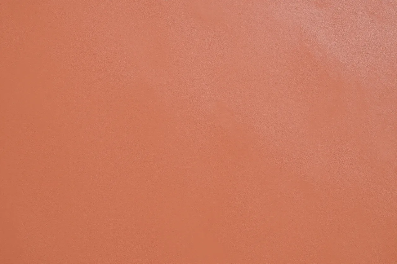 Full frame close-up of soft terracotta venetian plaster with a subtle polished sheen