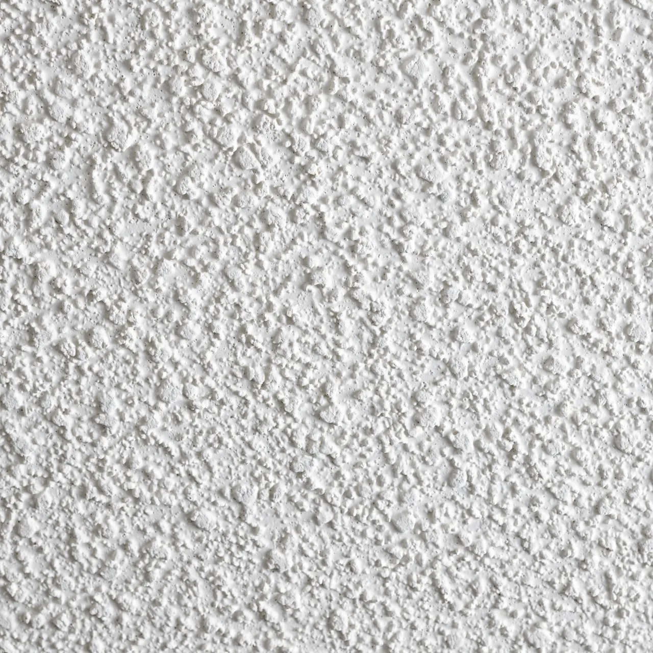 Full frame close-up of rough, white sprayed popcorn ceiling acoustic texture with even lighting