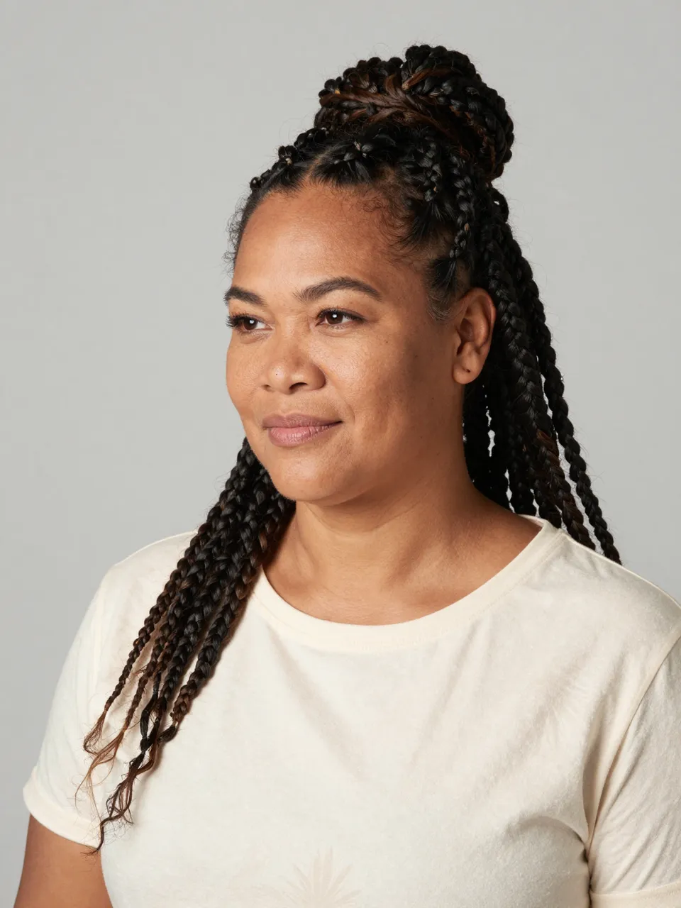 Studio portrait of a Pacific Islander woman in her thirties with half-up braided top knot wearing a cream t-shirt