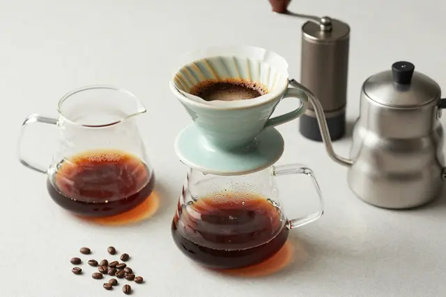 Flat lay view of a full pour-over coffee brewing arrangement on a light neutral countertop