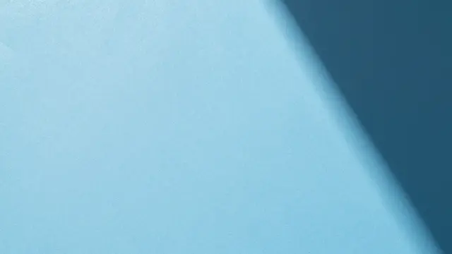 Textured powder blue paper backdrop with a soft diagonal curved gradient shadow.
