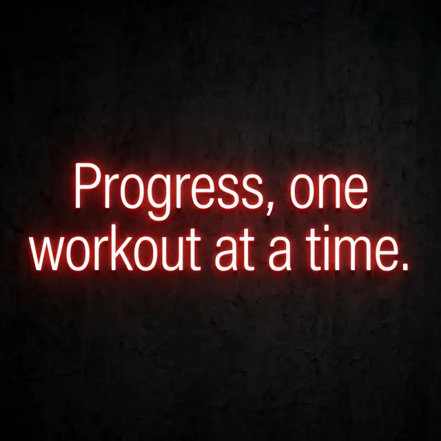 Glowing red neon sign displaying the quote "Progress, one workout at a time." on a dark textured gym wall
