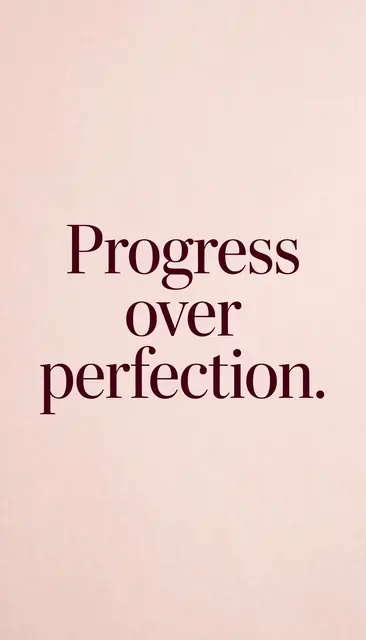 "Progress over perfection." displayed in deep burgundy serif type on a soft blush pink background, formatted as a phone