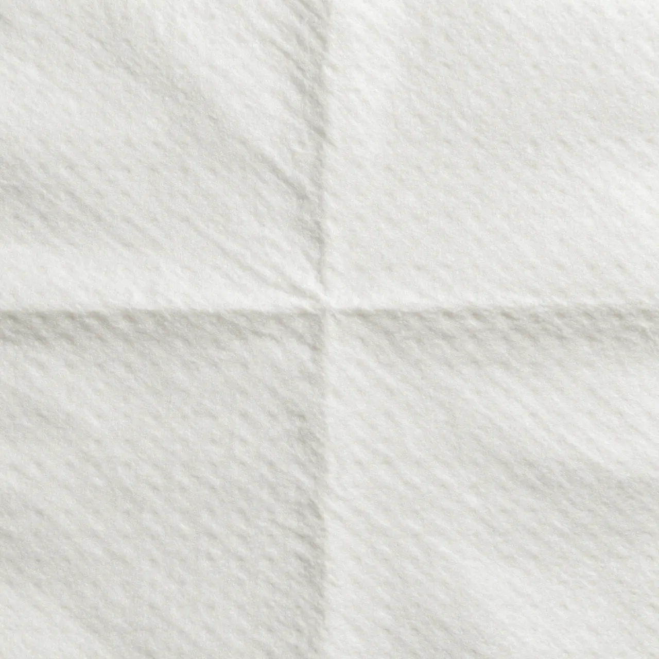 Full frame top view of soft embossed white quilted paper towel surface with even lighting