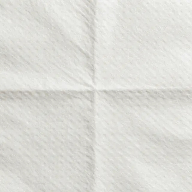 Full frame top view of soft embossed white quilted paper towel surface with even lighting