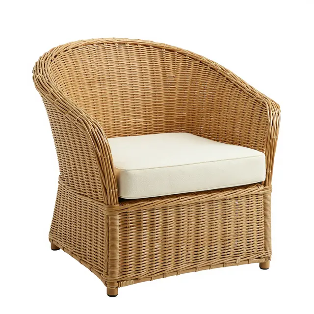 A round woven rattan accent chair with a cream cushion sits against a plain white studio background.