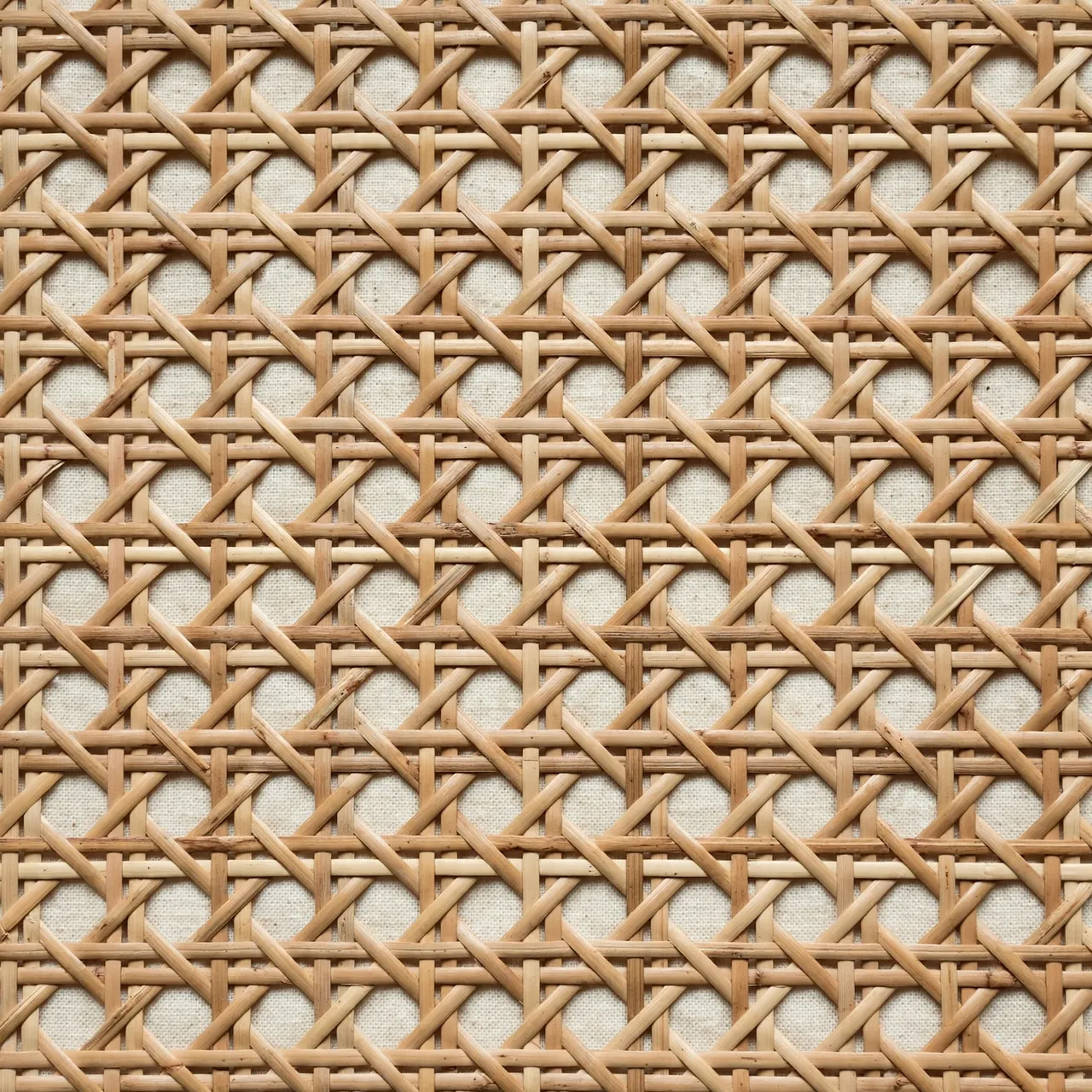 Full frame close-up of classic six-way rattan cane webbing over an underlayer of cream woven cloth