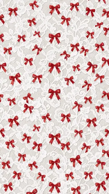 Scattered tiny red satin ribbon bows rest over an ornate white floral lace background designed for wallpaper use