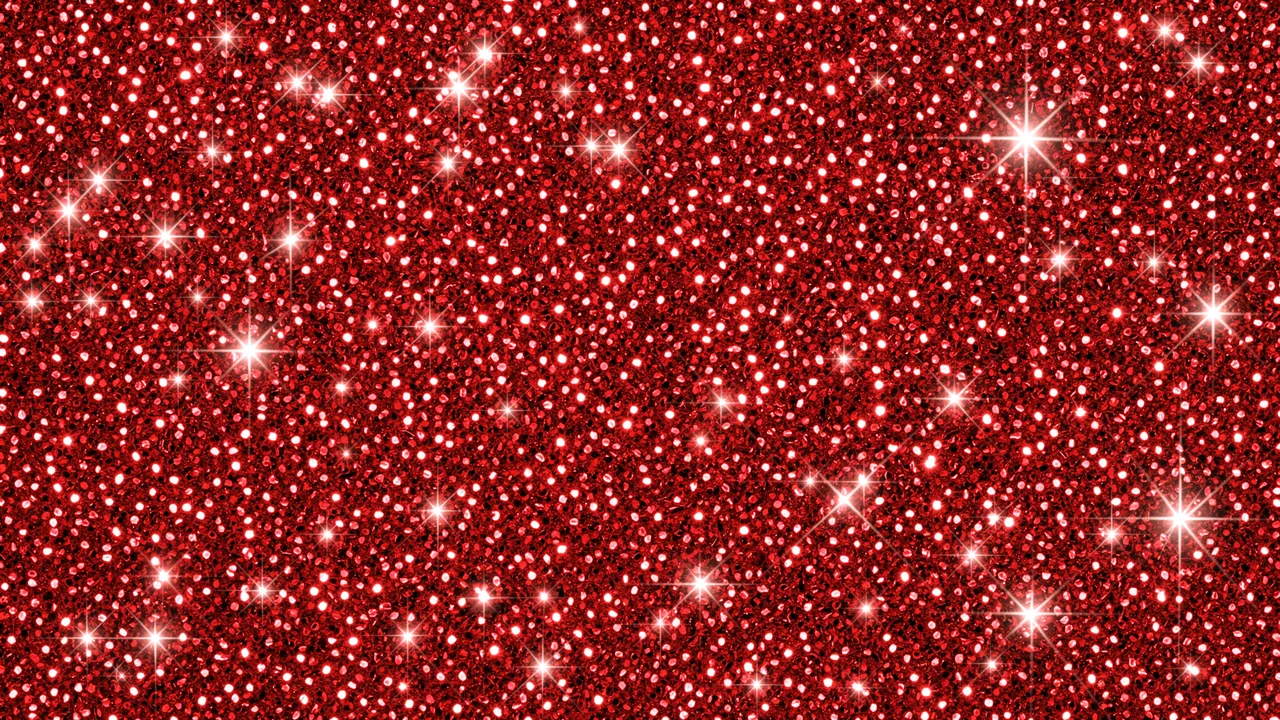Full frame vibrant red glitter surface scattered with bright sparkling starburst highlights