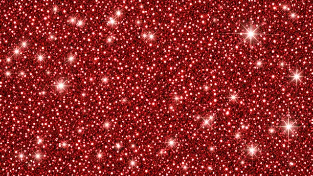 Full frame vibrant red glitter surface scattered with bright sparkling starburst highlights