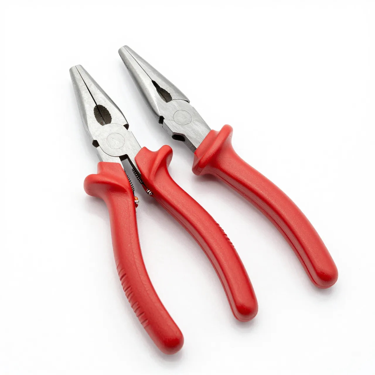Two long-nose pliers with red rubber handles rest on a plain white studio background