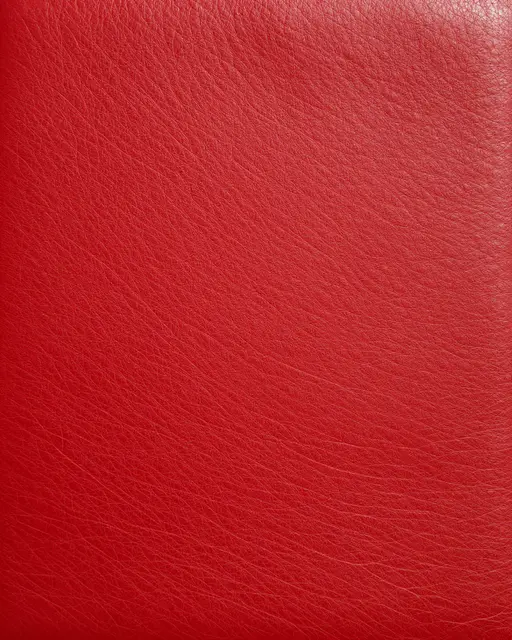Full frame close-up of smooth deep crimson red leather with fine natural grain and even lighting