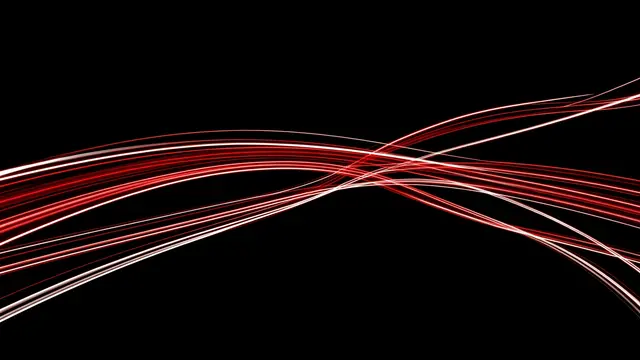 Curving overlapping red and white long exposure light trails stretch across a solid pure black background