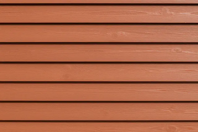 Full frame close-up of horizontal reddish-brown cedar clapboard siding with crisp shadow gaps between planks