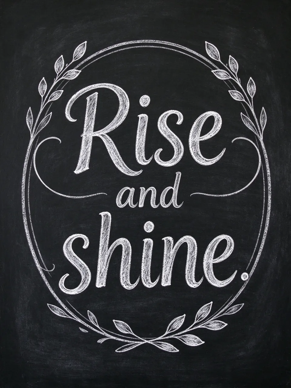 Chalk lettering reading "Rise and shine." surrounded by decorative flourishes on a black chalkboard