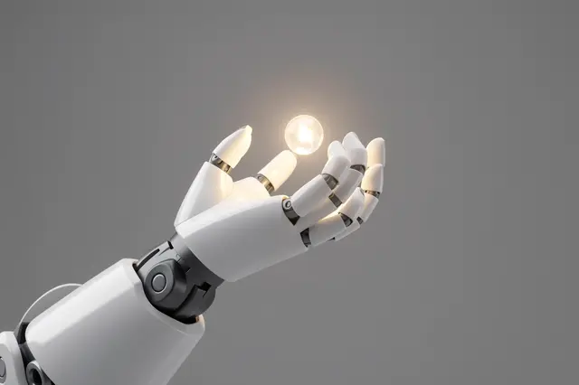 A white robotic hand holds a small glowing floating orb against a plain gray background