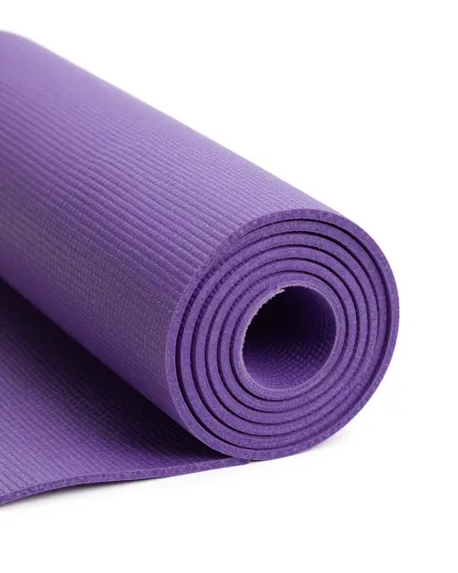 Partially rolled textured purple yoga mat isolated on a pure white studio background