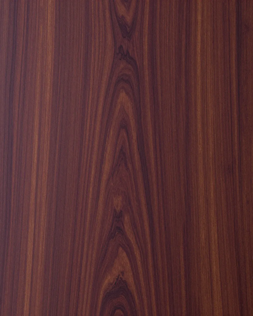 Full frame flat lay close-up of purplish brown rosewood with swirling dark grain lines