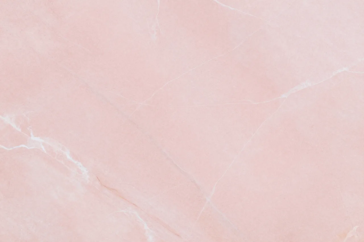 Full frame close-up of soft rosy pink marble with delicate pale linear veining