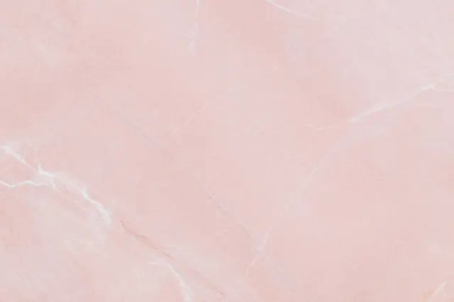 Full frame close-up of soft rosy pink marble with delicate pale linear veining
