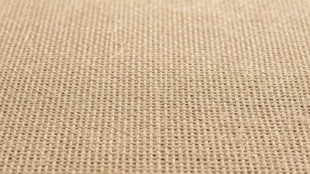 Close-up of natural tan rough woven burlap fabric with a soft even weave pattern