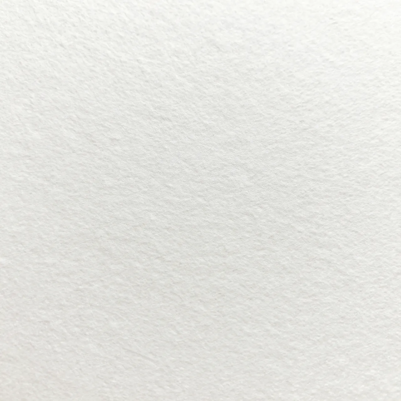 Close-up full frame view of textured bright white cold-press watercolor paper grain