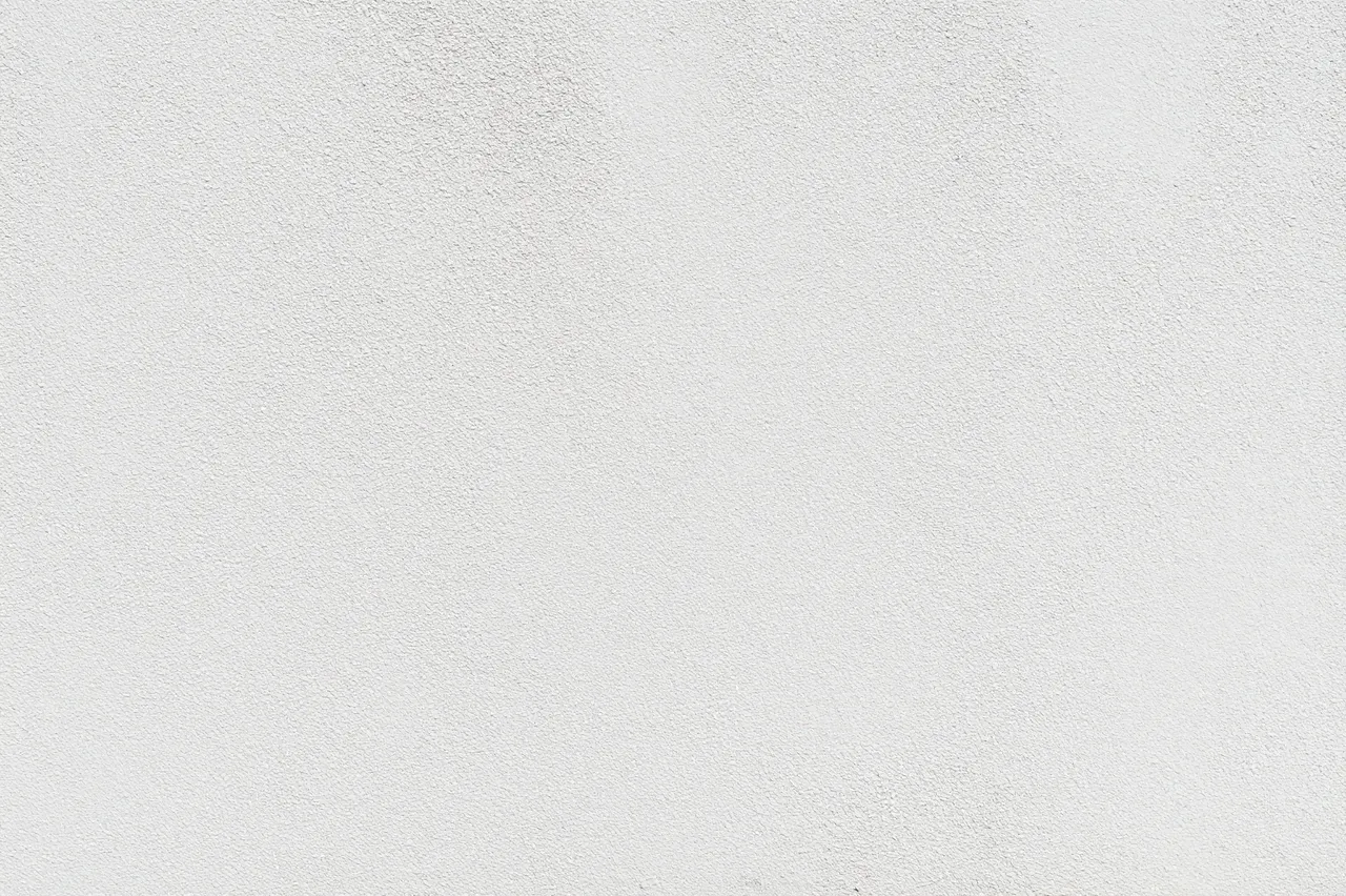 Full frame close up of a fine textured matte white stucco wall surface