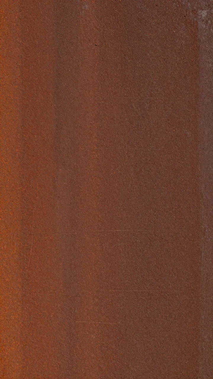 Full frame close-up of a weathered rust-brown metal surface with faint fine scratches and flat even lighting