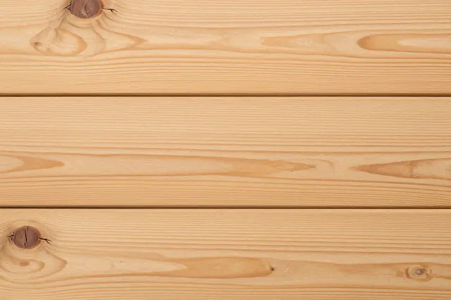 Full frame top view of light rustic oak planks with natural grain and dark knots under even lighting