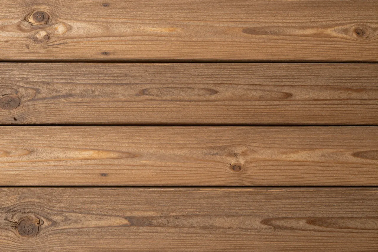 Close up top view of horizontal warm brown rustic wooden planks with natural grain and knots