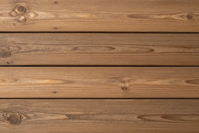 Close up top view of horizontal warm brown rustic wooden planks with natural grain and knots
