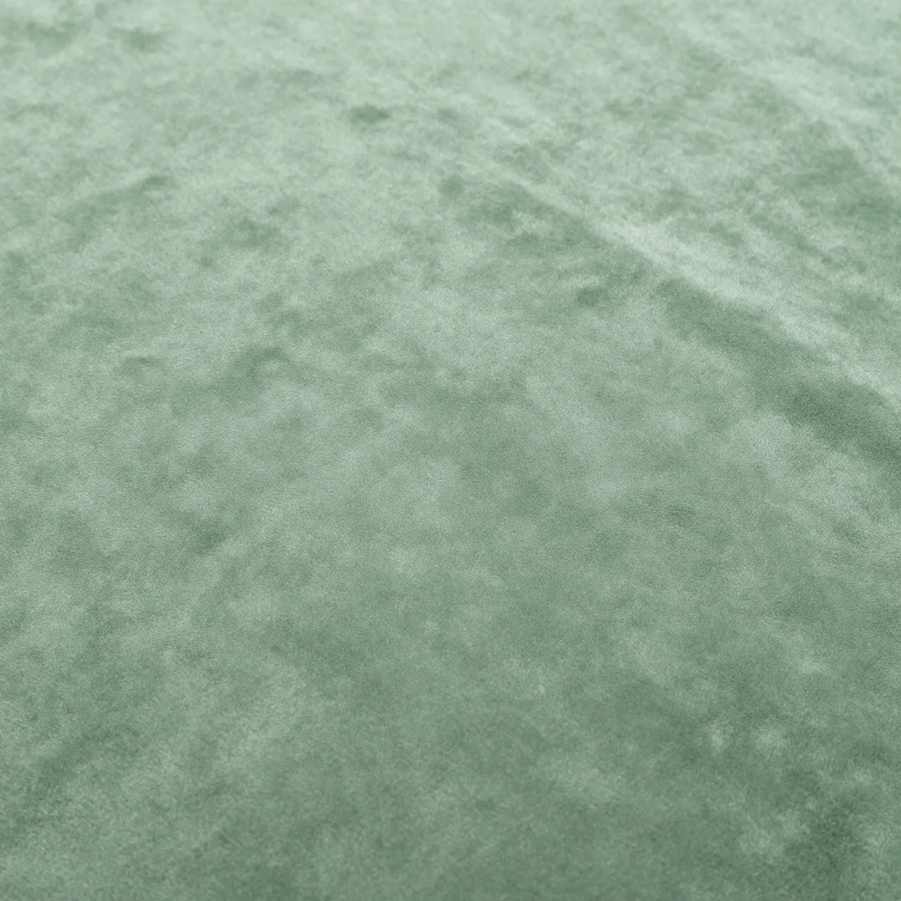 Full frame close-up of soft sage green chenille fabric with a gentle velvety pile
