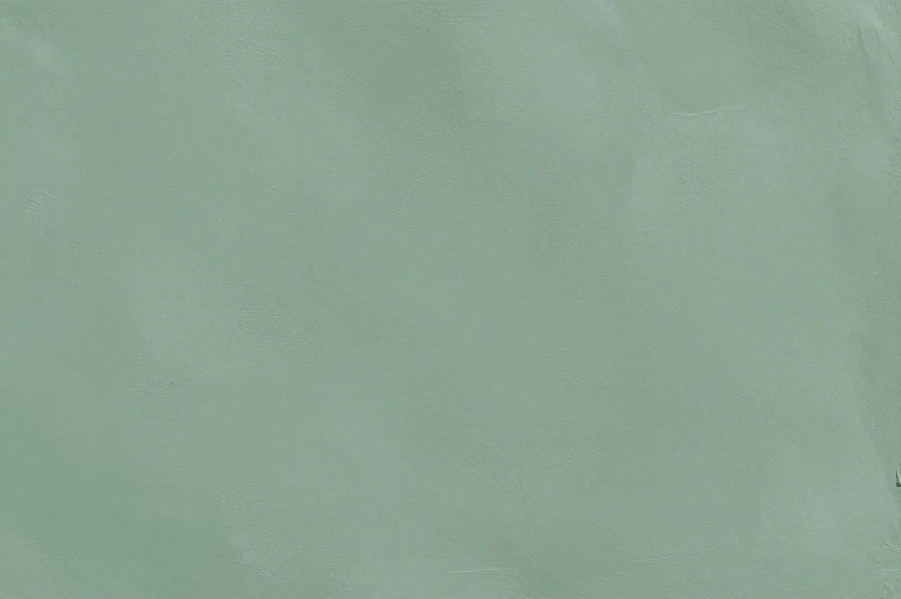 Full frame close-up of smooth sage green limewash plaster with soft cloudy tonal variations