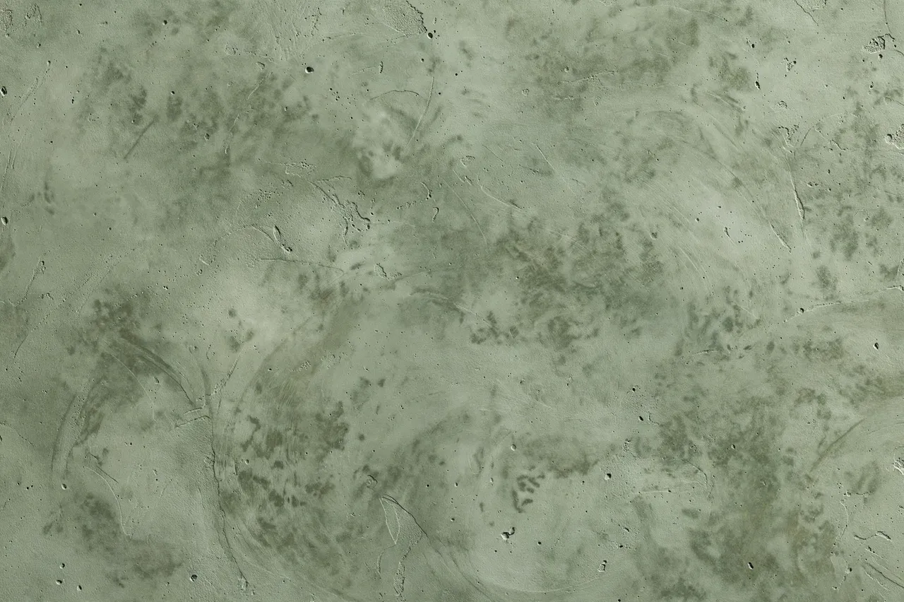 Full frame straight-on view of troweled sage green microcement surface with soft mottling and fine pinholes
