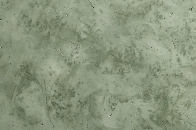 Full frame straight-on view of troweled sage green microcement surface with soft mottling and fine pinholes