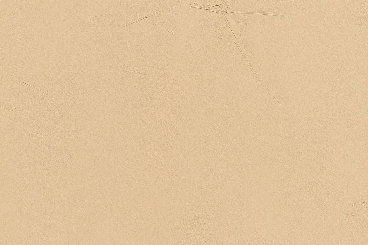 Full frame close-up of a sand-toned limewash wall with subtle faint brush marks