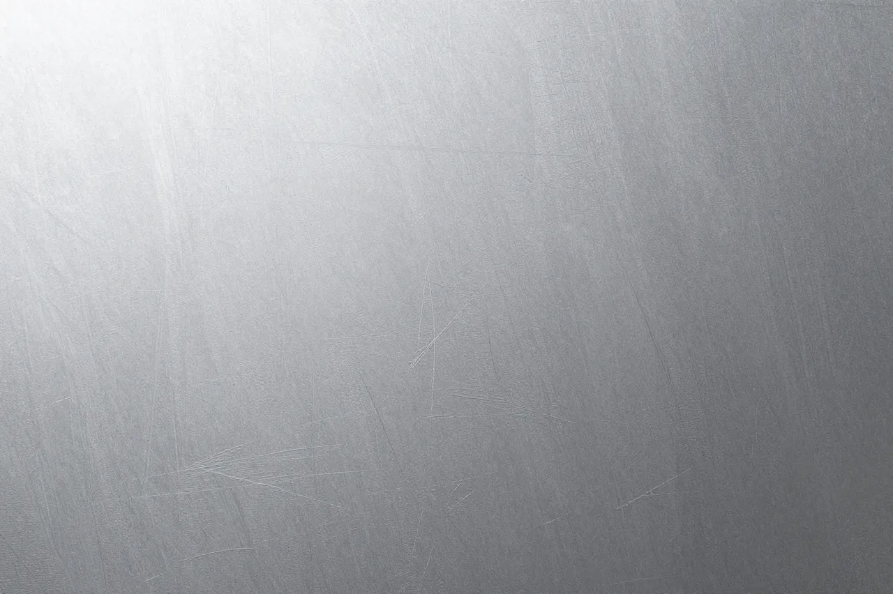 Full frame close-up of a gently scratched matte brushed aluminum surface with soft gradient lighting