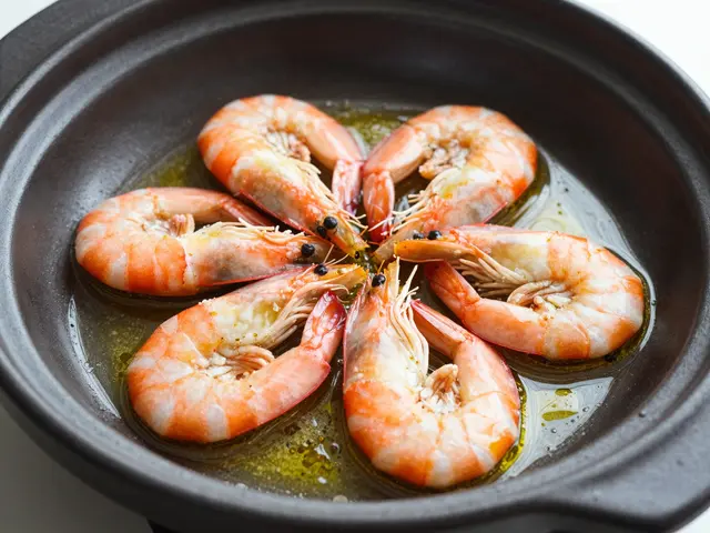 Cooked shrimp arranged in a circle sitting in olive oil inside a dark clay serving dish