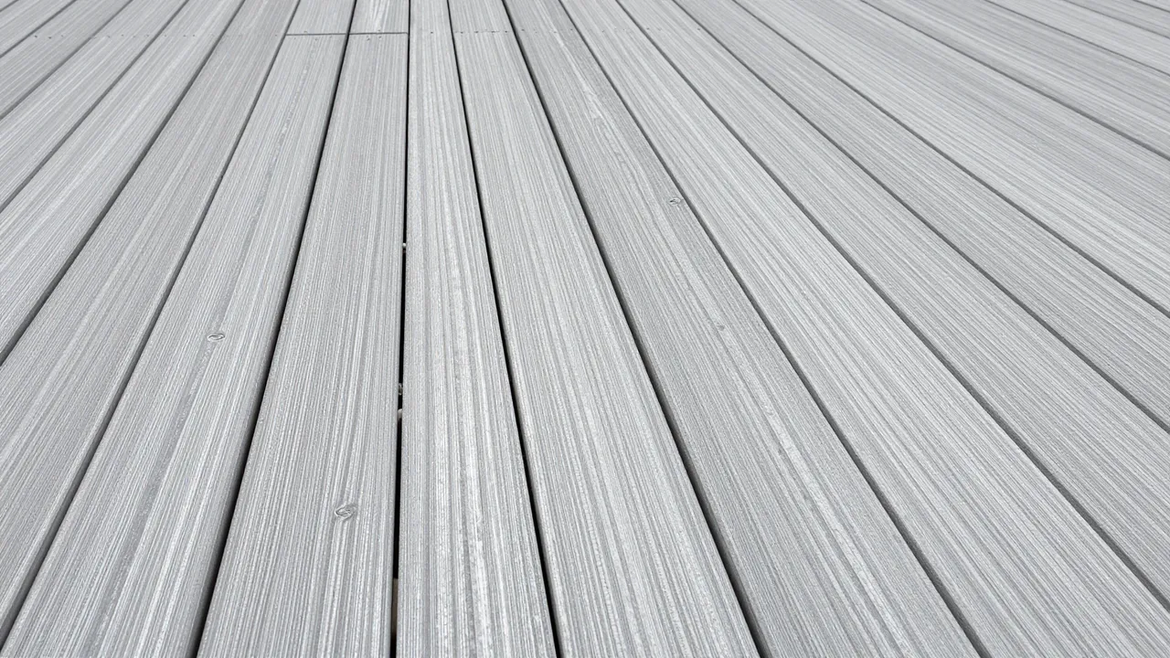 Close-up top view of parallel silver weathered teak decking boards under overcast light