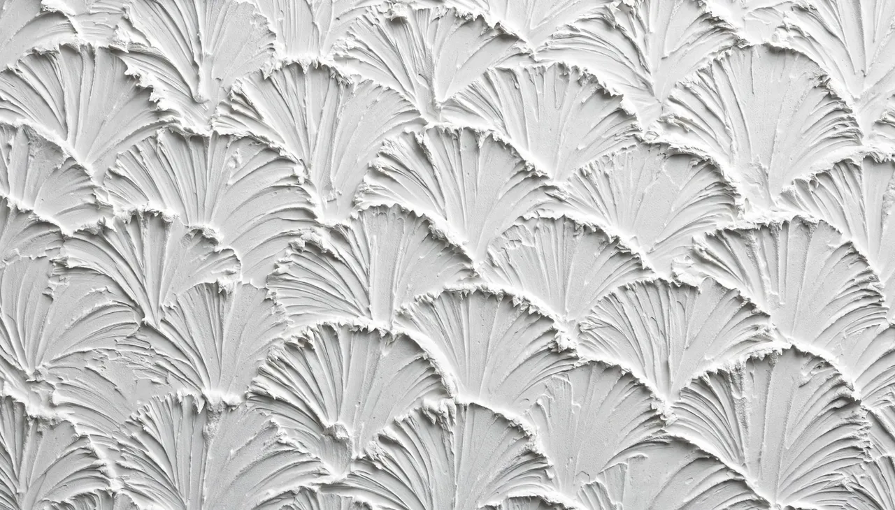 Full frame close-up of white slap brush ceiling texture with overlapping fan-shaped drywall mud ridges