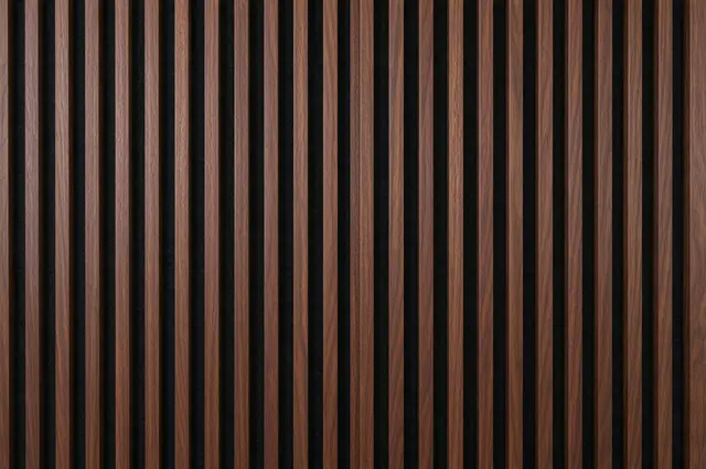 Full frame close-up of upright walnut wood slats over black acoustic felt with even spacing