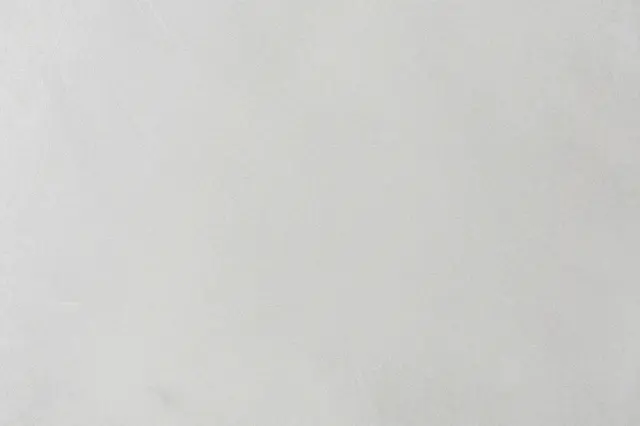 Full frame close-up of a smooth light gray cement surface with faint subtle trowel marks