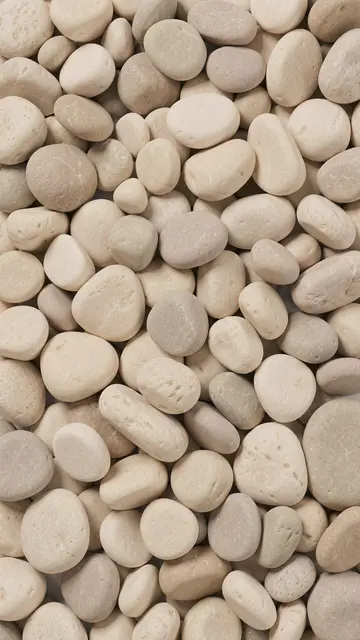 Dense full frame of rounded smooth river stones in soft cream, taupe and beige tones