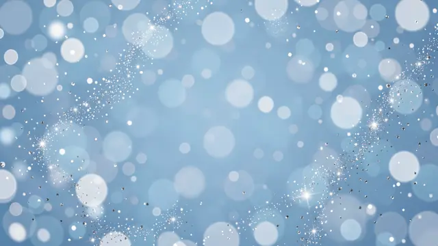 A soft light blue bokeh background with scattered silver sparkles and clear central copy space