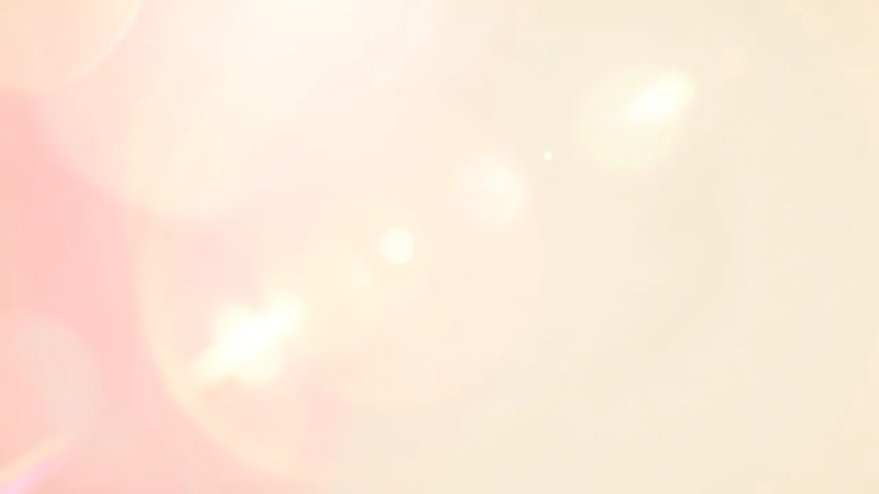 Warm soft pink and golden light leak bokeh flares drift over a pale cream background