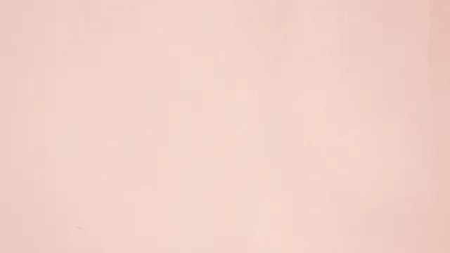 Smooth light pink plaster wall lit by soft warm morning sunlight