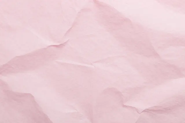 Full frame close-up of crumpled soft pink tissue paper with fine natural wrinkles