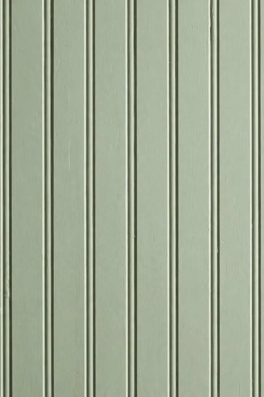 Full frame close-up of matte painted sage green beadboard paneling with vertical grooves