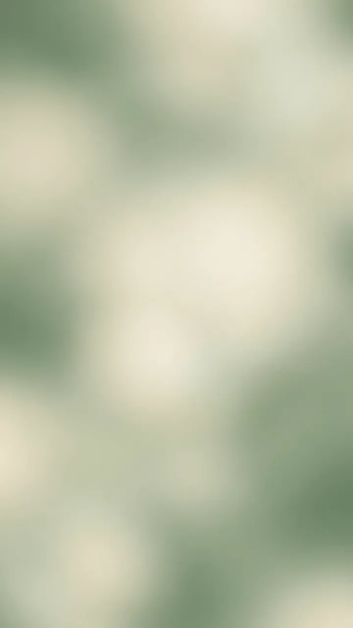 A smooth blurred vertical gradient of sage green and pale cream with soft grain and faint glowing highlights